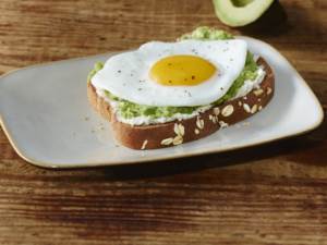 fried egg on avocado spread on toast on a plate