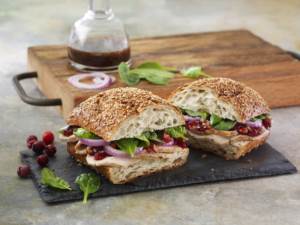 Balsamic Cranberry Turkey Sandwich cut in two on slate cutting board